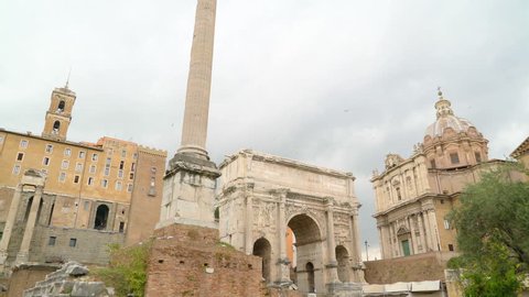 The tallest tower in the side of the Arch of Septimius Severus and the rubbles and rocks on the ground in Palatino Rome Italy