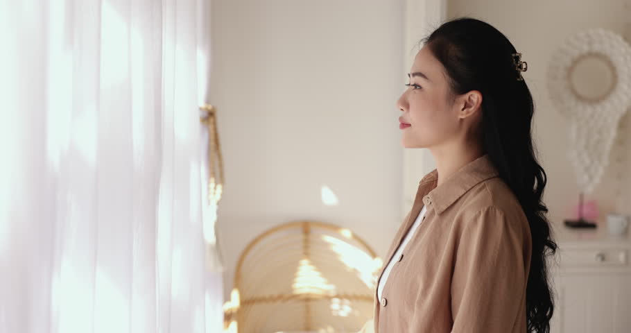 Side profile view happy Chinese woman opens curtain and admiring outside view from window at her new own or rented apartment. Welcoming new daytime in morning, start new day feel happy and optimistic Royalty-Free Stock Footage #3484614599