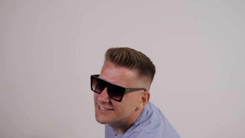 Portrait of a happy, cheerful man in sunglasses with a passport with a plane ticket and a globe on a white background. The concept of tourism and travel.