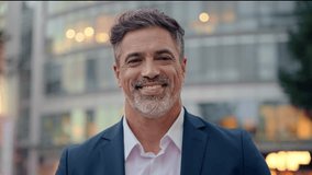 Mature hispanic senior business man standing on busy city street. Headshot close up portrait of Indian or latin confident good looking middle age male entrepreneur businessman happy smiling at camera. - Powered by Shutterstock - Get 15% off with code: PIKWIZARD15