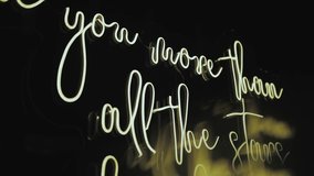 Close-up neon glowing wedding lettering I love you more than all the stars hanging on the wall, black background, wedding decoration, neon lights. slow motion.  - Powered by Shutterstock - Get 15% off with code: PIKWIZARD15
