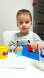 Little baby boy playing with colorful toys. Playful cute kid with plastic toy. Vertical video.