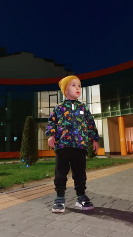 Small kid boy walking in the park. Cute little child in the evening.