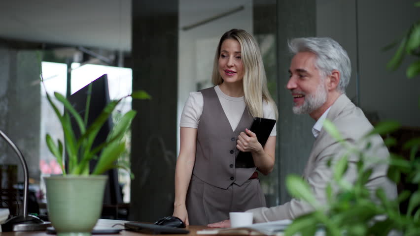 Manager talking with his employee in modern office. Company director is happy, satisfied for workers quality work.