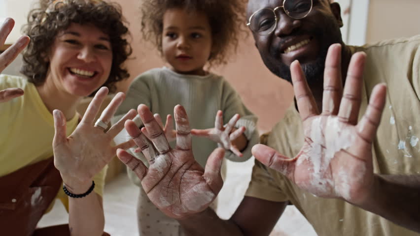 Medium portrait of happy multiethnic family showing stained palms to camera and smiling during home renovation Royalty-Free Stock Footage #3484959641