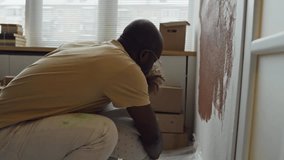 Side footage of caring African American father helping his Biracial child learn to paint walls using paint roller during home redecoration - Powered by Shutterstock - Get 15% off with code: PIKWIZARD15