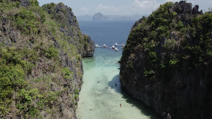 flies over a big lagoon in El Nido with canoe palawan