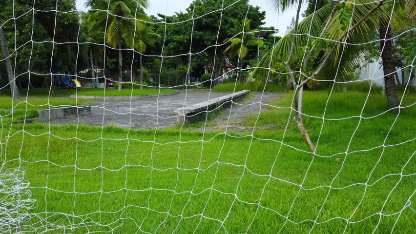Goal post with the net pierced on grassy soccer field Royalty-Free Stock Footage #3485096465