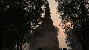 The natural video background of the big sun setting behind the rice fields or behind the old pagoda, Wat Phra Ngam (Portal of Time), is a beauty that happens naturally while traveling in Thailand.