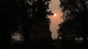 The natural video background of the big sun setting behind the rice fields or behind the old pagoda, Wat Phra Ngam (Portal of Time), is a beauty that happens naturally while traveling in Thailand.
