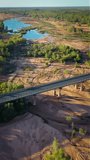 Aerial shot of car driving over bridge and a beautiful sandy riverbed in late afternoon, Grey River,  Australia, vertical video