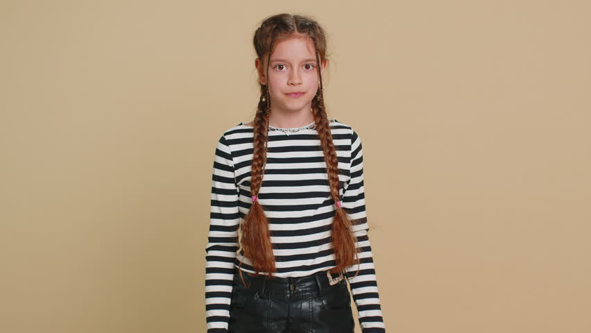 Oh my God, Wow. Young preteen child girl kid looking surprised at camera with big eyes, shocked by sudden victory game winning lottery goal achievement good news. Children isolated on beige background