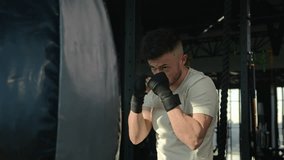 Strong man in boxing gloves training with punching bag in gym professional box workout exercise sports athlete boxer fighter champion with power strong motivation hitting beating prepare for fighting - Powered by Shutterstock - Get 15% off with code: PIKWIZARD15