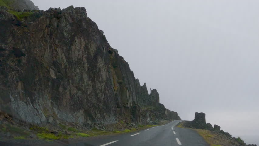 Tranquil misty mountain road landscape with fog. Rocky terrain. And a sea view on a remote and deserted coastal road. Offering a scenic and atmospheric mood for outdoor adventure.