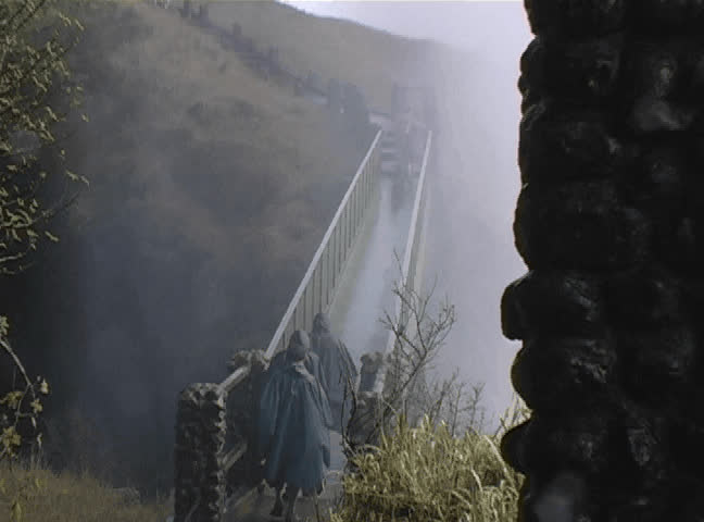Travelers crossing a foot bridge in the water mist of Victoria Falls on Zambia side