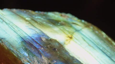 MACRO: Mesmerizing iridescent tecosilicate mineral sparkling under light. Glowing feldspar revealing its multicolor structure. Labradorite crystal with healing properties igniting spiritual expansion