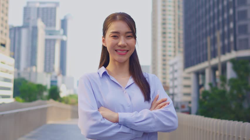 Portrait of Asian youg beautiful businesswoman standing outdoor in city. Attractive employee girl worker feel happy and confident then smile, looking at camera. Job application and recruitment concept