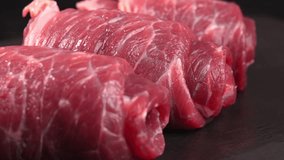 Thin raw marbled beef rolls close up. Juicy raw veal. Advertising of meat products, video for butcher shop, food festival. Flank steak for minced meat