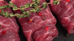 Sleek uncooked veal swirls or marbled beef with thyme and himalayan peppercorns pepper top view. Meat products ad, butcher's video, gastronomy showcase. Flank piece for grinding. Juicy red meat