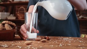 Man pouring fresh milk from jug into glass in morning, healthy food and nutrition, closeup view. Breakfast in village in summertime, young woman enjoying natural organic food and beverage on farm - Powered by Shutterstock - Get 15% off with code: PIKWIZARD15