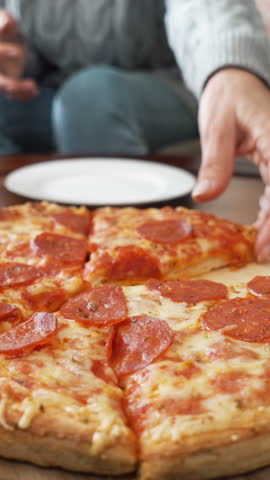Family sharing pizza. Human hands taking pieces slices of hot tasty italian pizza pepperoni. Tracking shot.