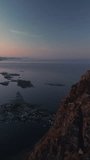 Vertical panoramic video smoothly transitions from right to left show the mountains of Reinebringen illuminated by midnight sun in Lofoten Islands, Norway