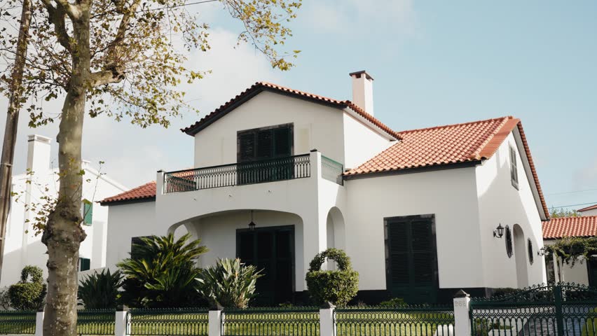 Modern country house with yard and fence outdoors at summer day. Exterior of suburban house. Real estate rental. 