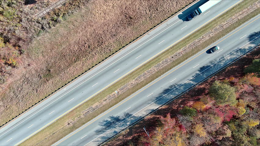 American highway with fast moving traffic surrounded by autumn colorful trees in forest in South Carolina USA