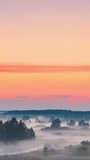 Vertical Footage Video Amazing Sunrise Over Misty Landscape. Scenic View Of Foggy Morning Sky With Rising Sun Above Misty Forest And River. Early Summer Nature Of Eastern Europe. Bold Colors.