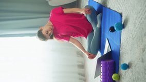 An online video in which a woman is doing a warm-up. She rotates her head, kneading the neck muscles. High quality 4k footage