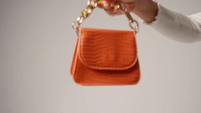 Close up video edited with jump cuts of female social media influencer producing user generated content holding out different coloured fashion handbags. - Powered by Shutterstock - Get 15% off with code: PIKWIZARD15