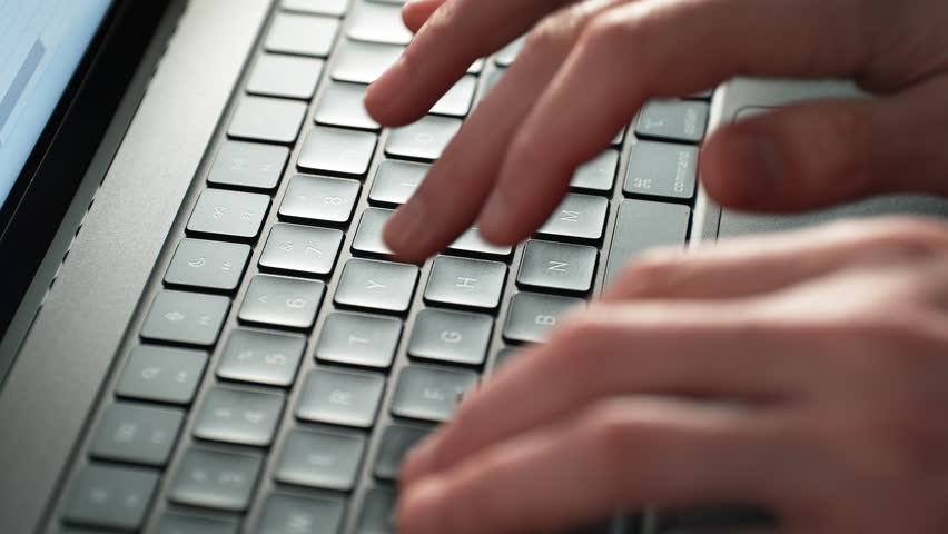 Alphanumeric Keys of the Laptop Keyboard Being Tapped by Fingers - Letters and Numbers are in Focus, the Hands Are Blurred