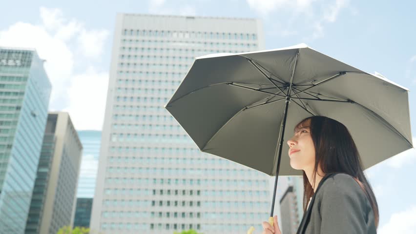 A woman holding a parasol in the city Royalty-Free Stock Footage #3486252339