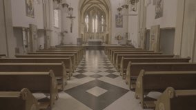 Moving forward through aisle to sanctuary in empty church. Christian cathedral interior with wooden pews rows, altar and black and white tile floor tilt up shot - Powered by Shutterstock - Get 15% off with code: PIKWIZARD15