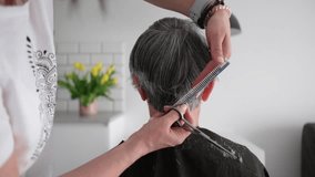 Hairdresser Trimming Elderly Woman'S Gray Hair At Home