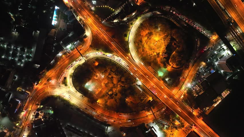 Beautiful top view time-lapse of car traffic at roundabout lane and buildings. drone aerial expressway. Urban cityscape concept or abstract of advanced innovation, financial technology, energy power Royalty-Free Stock Footage #3486294991