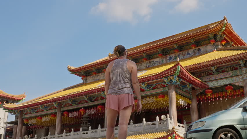 Parallax movement of woman looking at the majestic Kek Lok Si Temple Shrine Hall in George Town, Penang island, Malaysia
