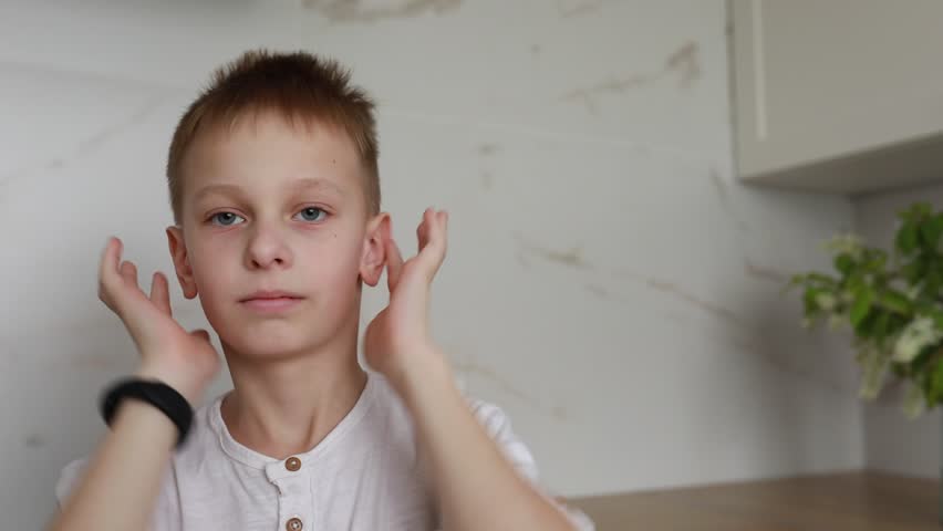 Young Boy Wincing in Discomfort Holding His Ears Indoors During Daytime Royalty-Free Stock Footage #3486479509