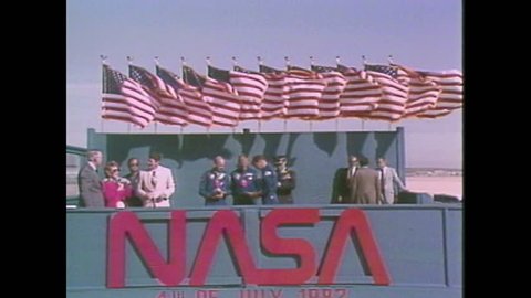 1980s: Astronauts stand talking with President Ronald Reagan and Nancy Reagan. They then walk across tarmac. Space Shuttle launches. Reagan gives speech. Space Shuttle on launch pad at night.