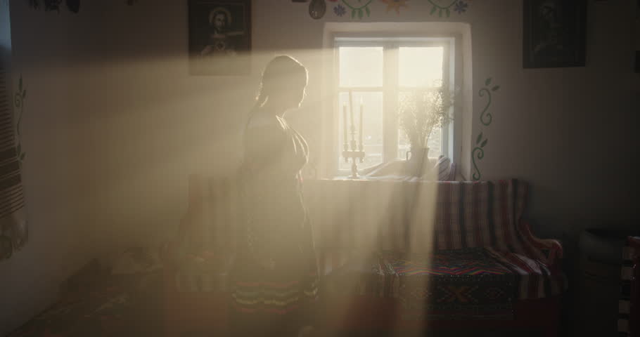 Young Girl in Ethnic Ukrainian Attire by Sunlit Window in Traditional House