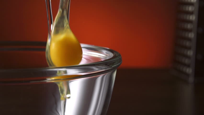 Man's Hand Cracking and pouring an Egg into a Bowl. Slow motion 250 fps.