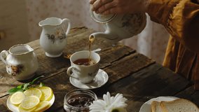 Tea party in rustic style. Pouring tea from teapot into porcelain cup. Morning breakfast. - Powered by Shutterstock - Get 15% off with code: PIKWIZARD15