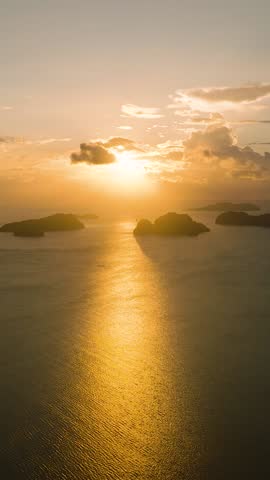 Drone view of sunset path over the sea. Golden sky and and clouds in El Nido, Palawan. Philippines. Vertical view. Royalty-Free Stock Footage #3486651531