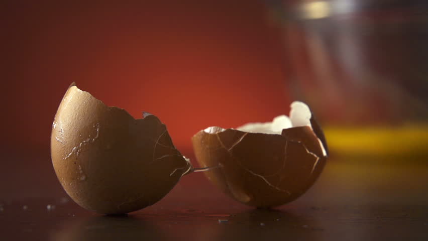 Cracked Egg Shells fall on table in slow motion, 250fps