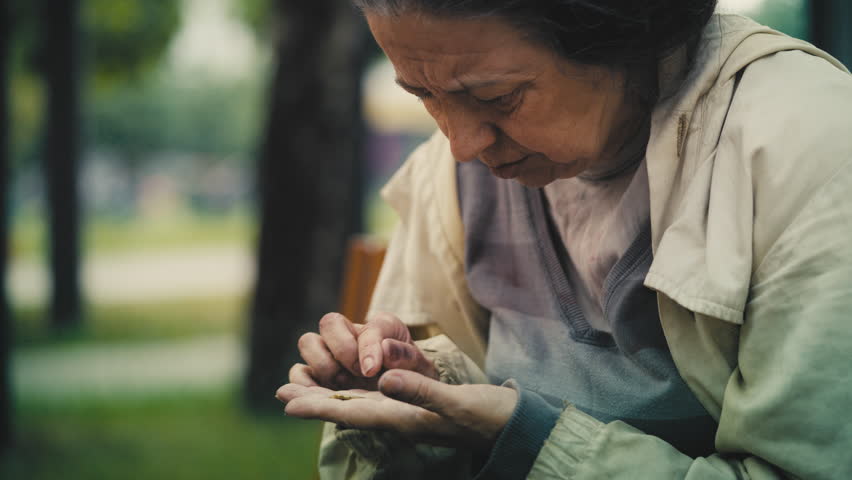 Hungry female beggar counting few coins in hand, social injustice, poverty