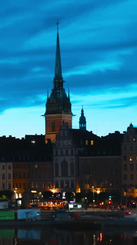 Stockholm, Sweden. Vertical Footage Video. Scenic Skyline View Of Famous Tower Of Stockholm City Hall. Building Of Municipal Council. Famous Popular Destination Place In Dusk Lights. Night Lighting.