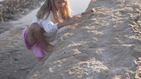 A heartwarming video of a young girl climbing on rocks by the beach, surrounded by natures beauty, showcasing the joy of adventure and leisure in the outdoors