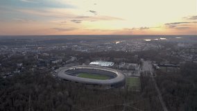 Drone video of the sunset over the city above Darius and Girenas Stadium in Kaunas, Lithuania. 2024.03.26