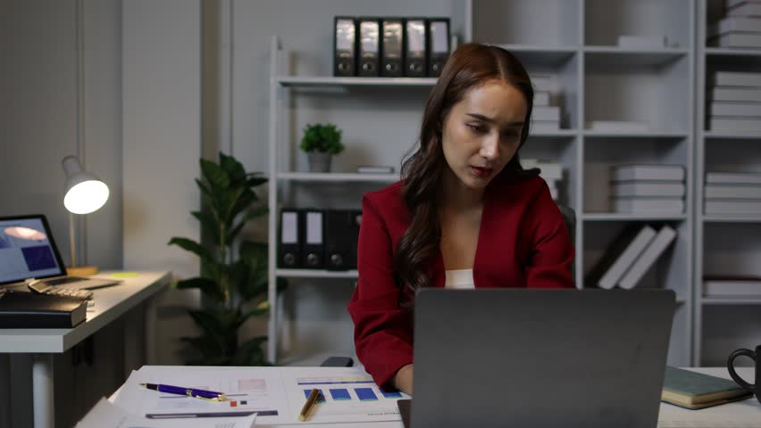 Serious business woman is working overtime in the office and is stressed from workload. Royalty-Free Stock Footage #3486919229