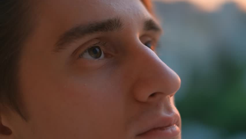Young inspired guy looking to the skies at sunset